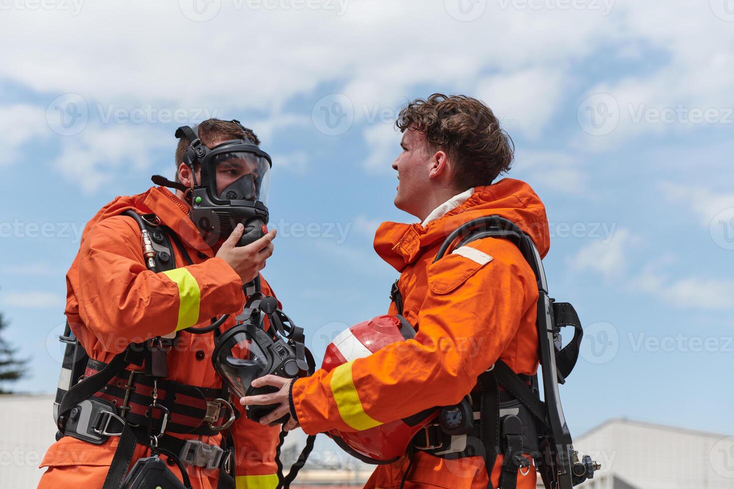 A unified team of firefighters, adorned in their uniforms, engages in a heartfelt celebration marked by triumphant salutes and cheers, embodying the joy and gratitude following the successful photo