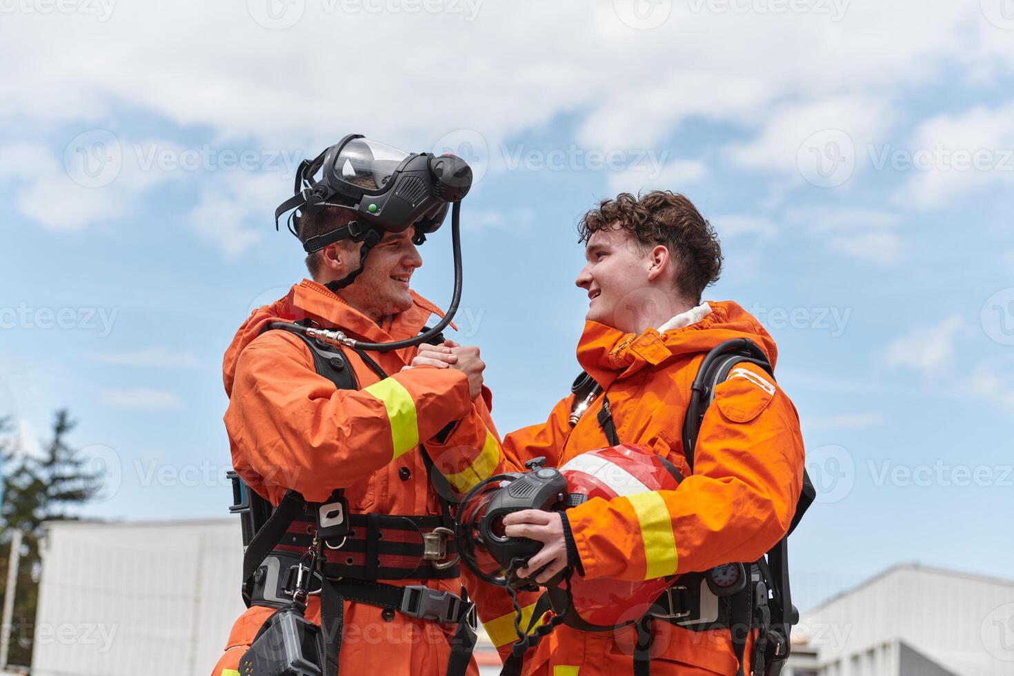 A unified team of firefighters, adorned in their uniforms, engages in a heartfelt celebration marked by triumphant salutes and cheers, embodying the joy and gratitude following the successful photo