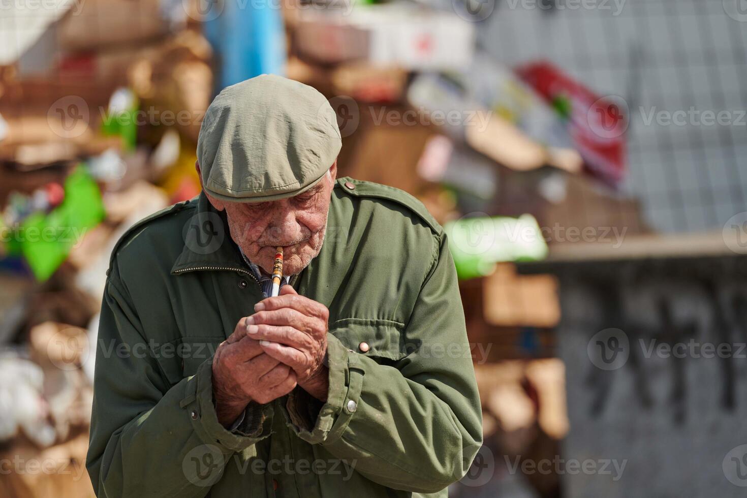Older Man Smoking Cigarette in Dark Green Jacket and Cap photo