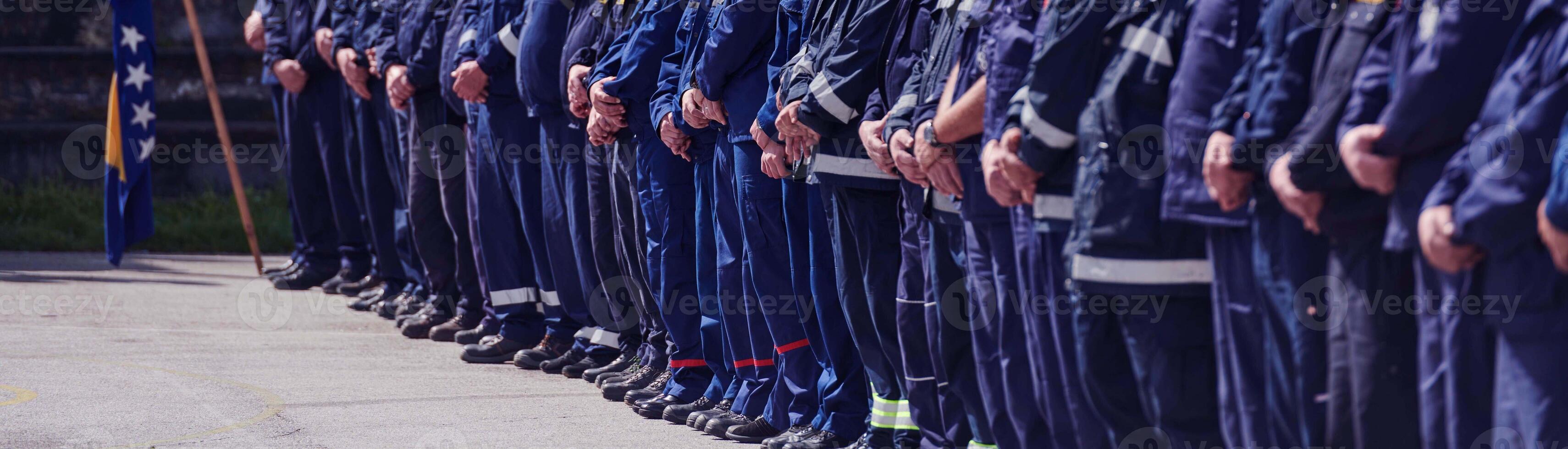 A group of firefighters lined up, saluting the flag, applauding in solidarity, and gearing up for intensive training sessions, showcasing their unwavering commitment to service and teamwork. photo