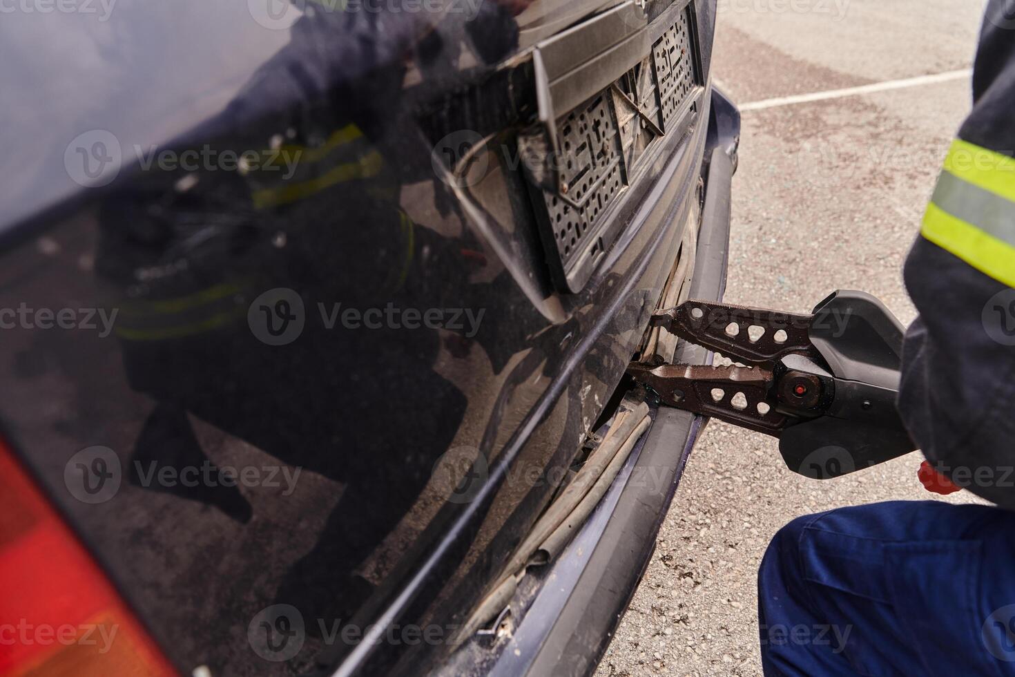 A dedicated team of professional firefighters employs specialized tools to cut and break through vehicle wreckage, showcasing their skilled collaboration and swift response in rescuing individuals photo
