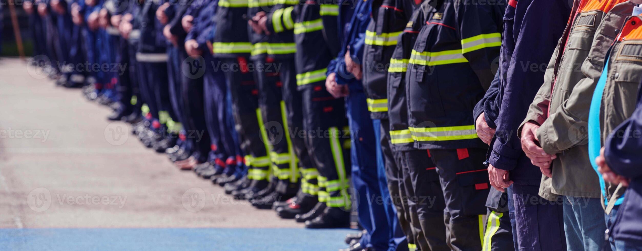 A group of firefighters lined up, saluting the flag, applauding in solidarity, and gearing up for intensive training sessions, showcasing their unwavering commitment to service and teamwork. photo
