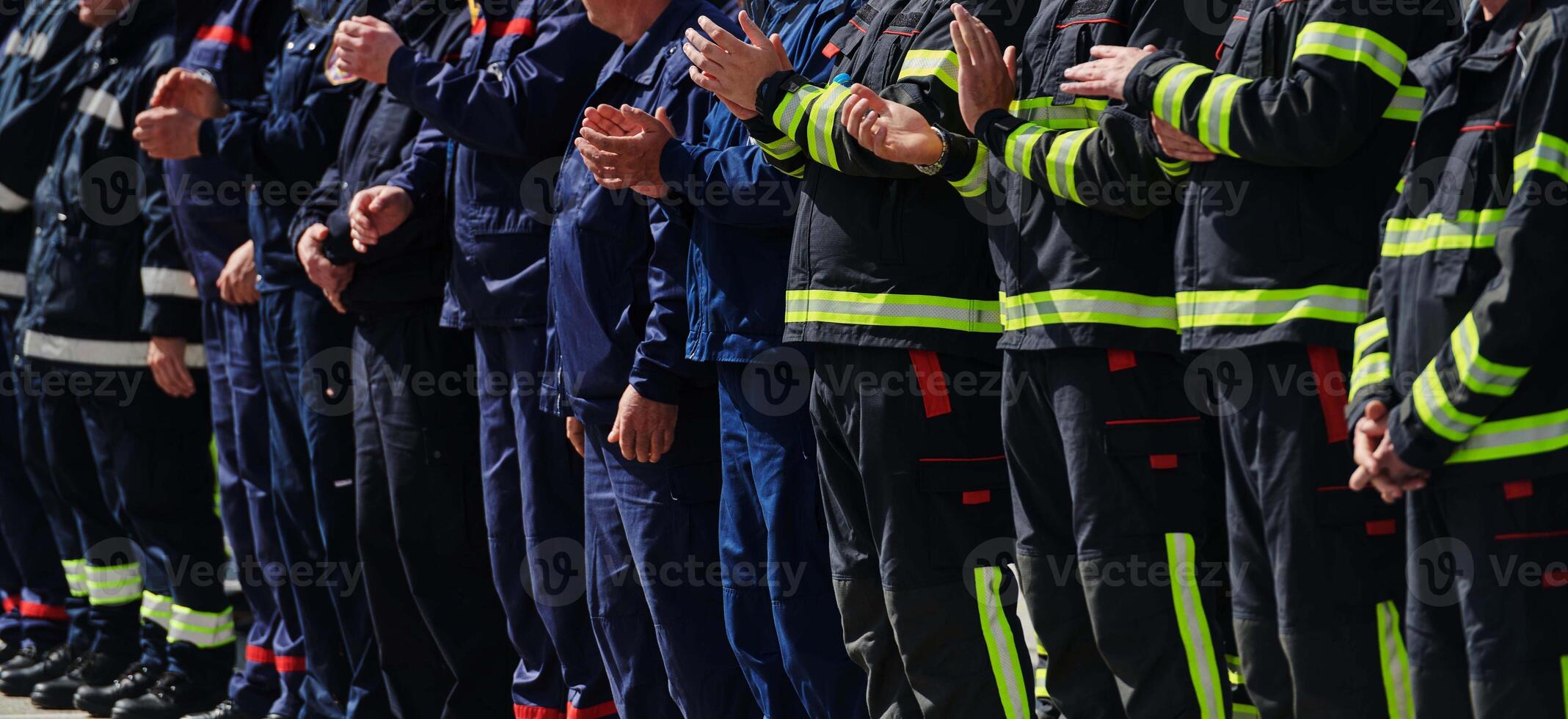 A group of firefighters lined up, saluting the flag, applauding in solidarity, and gearing up for intensive training sessions, showcasing their unwavering commitment to service and teamwork. photo