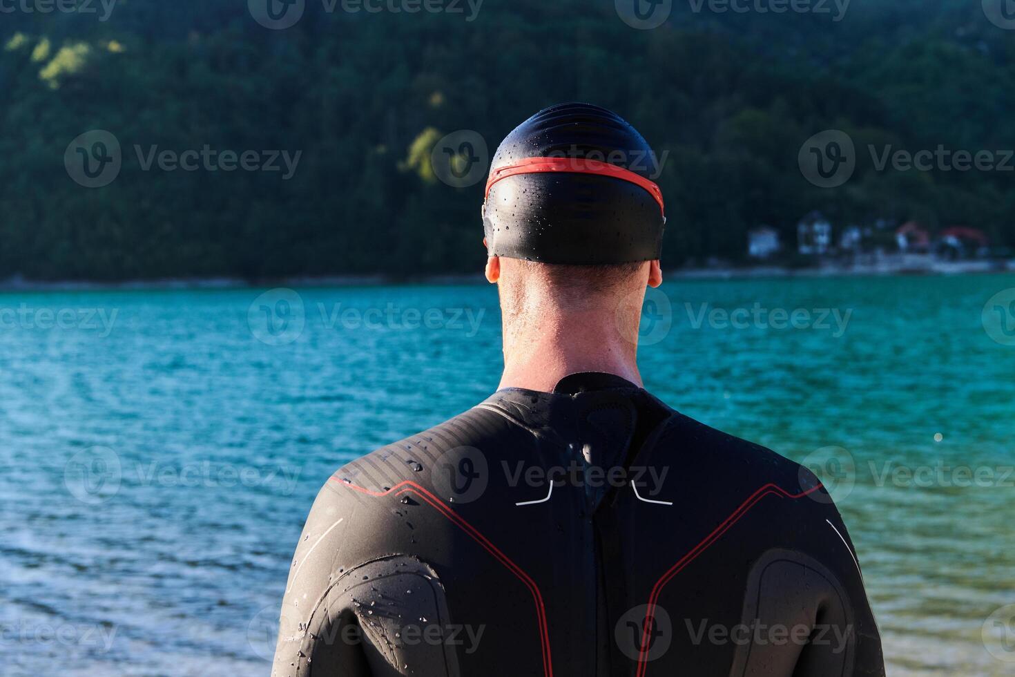 Authentic triathlon athlete getting ready for swimming training on lake photo