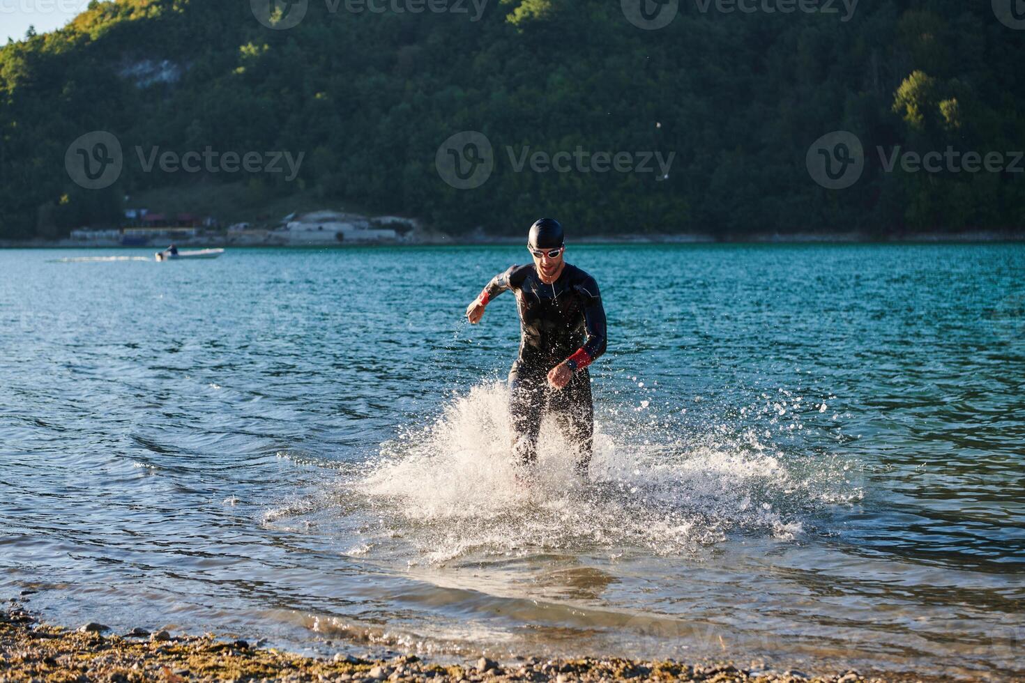 Triathlon athlete starting swimming training on lake photo