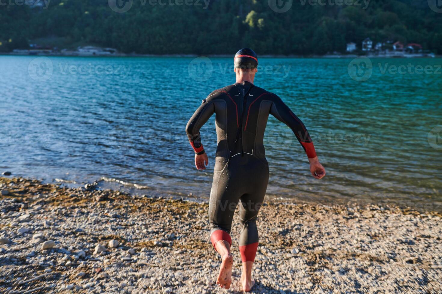 Triathlon athlete starting swimming training on lake photo