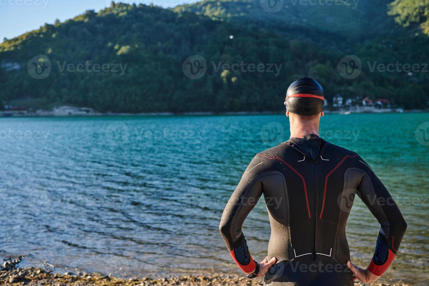 Authentic triathlon athlete getting ready for swimming training on lake photo