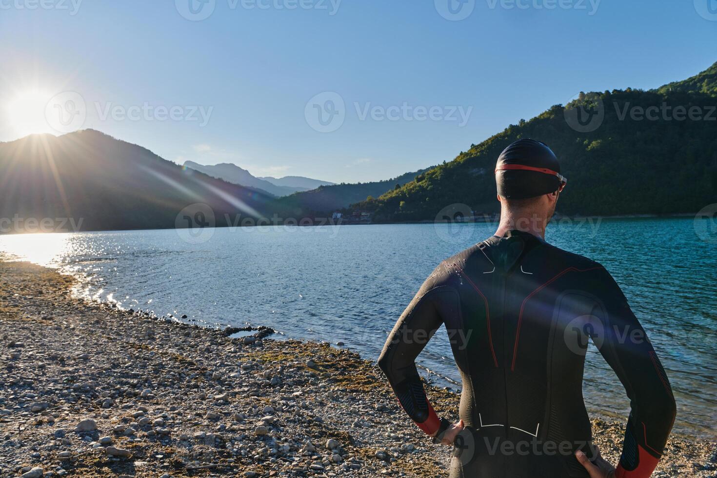 Authentic triathlon athlete getting ready for swimming training on lake photo