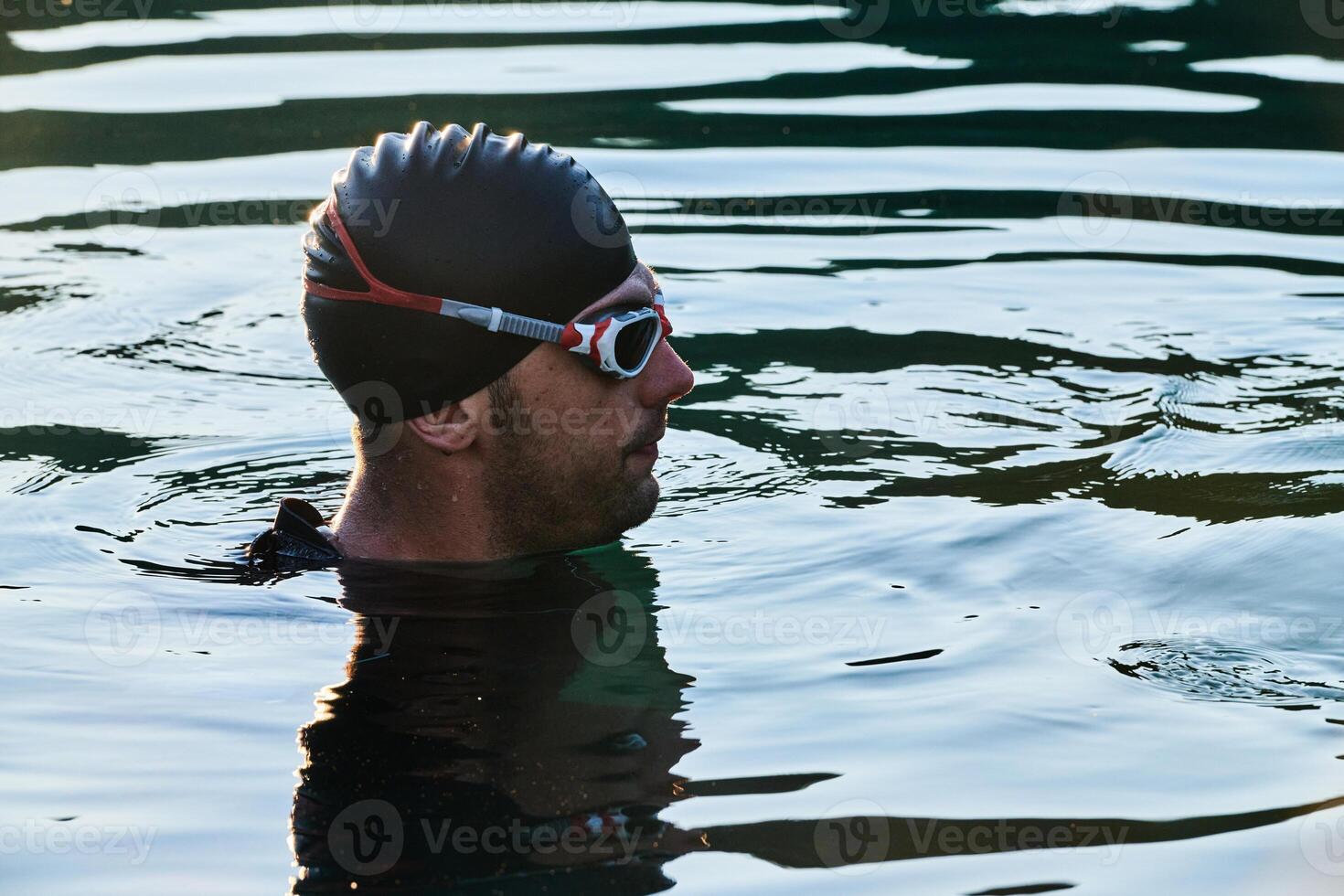 A triathlete finds serene rejuvenation in a lake, basking in the tranquility of the water after an intense training session photo