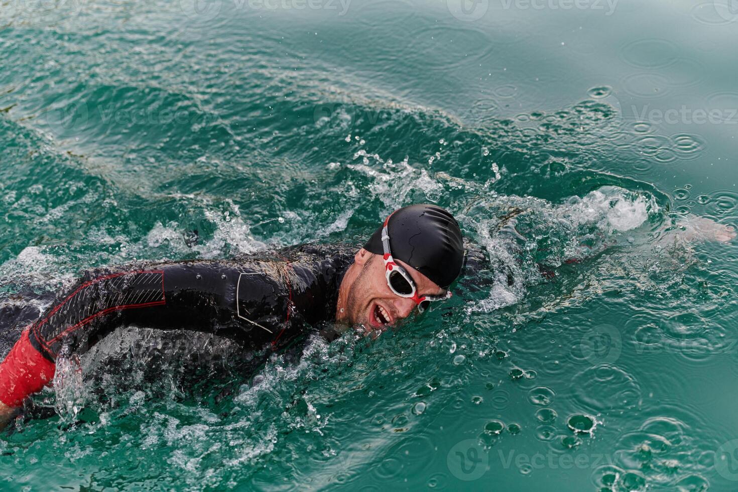 A professional triathlete trains with unwavering dedication for an upcoming competition at a lake, emanating a sense of athleticism and profound commitment to excellence. photo
