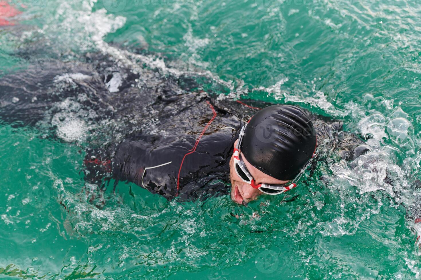 A professional triathlete trains with unwavering dedication for an upcoming competition at a lake, emanating a sense of athleticism and profound commitment to excellence. photo