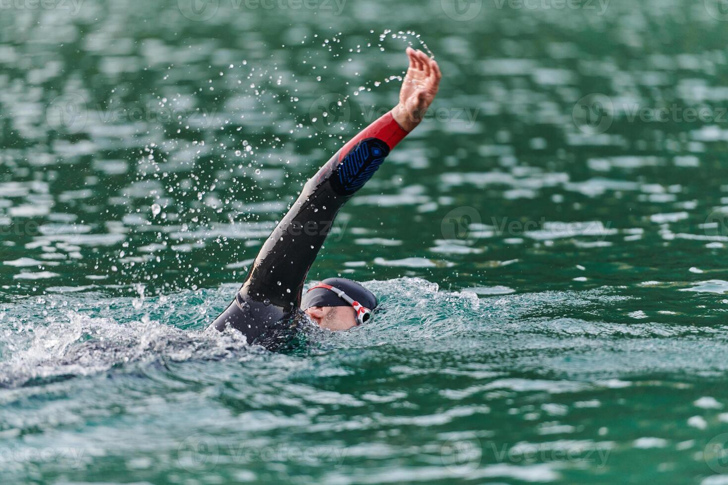 A professional triathlete trains with unwavering dedication for an upcoming competition at a lake, emanating a sense of athleticism and profound commitment to excellence. photo