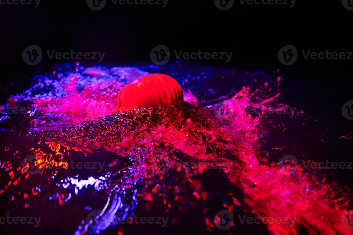 Authentic triathlete swimmer having a break during hard training on night neon gel light photo