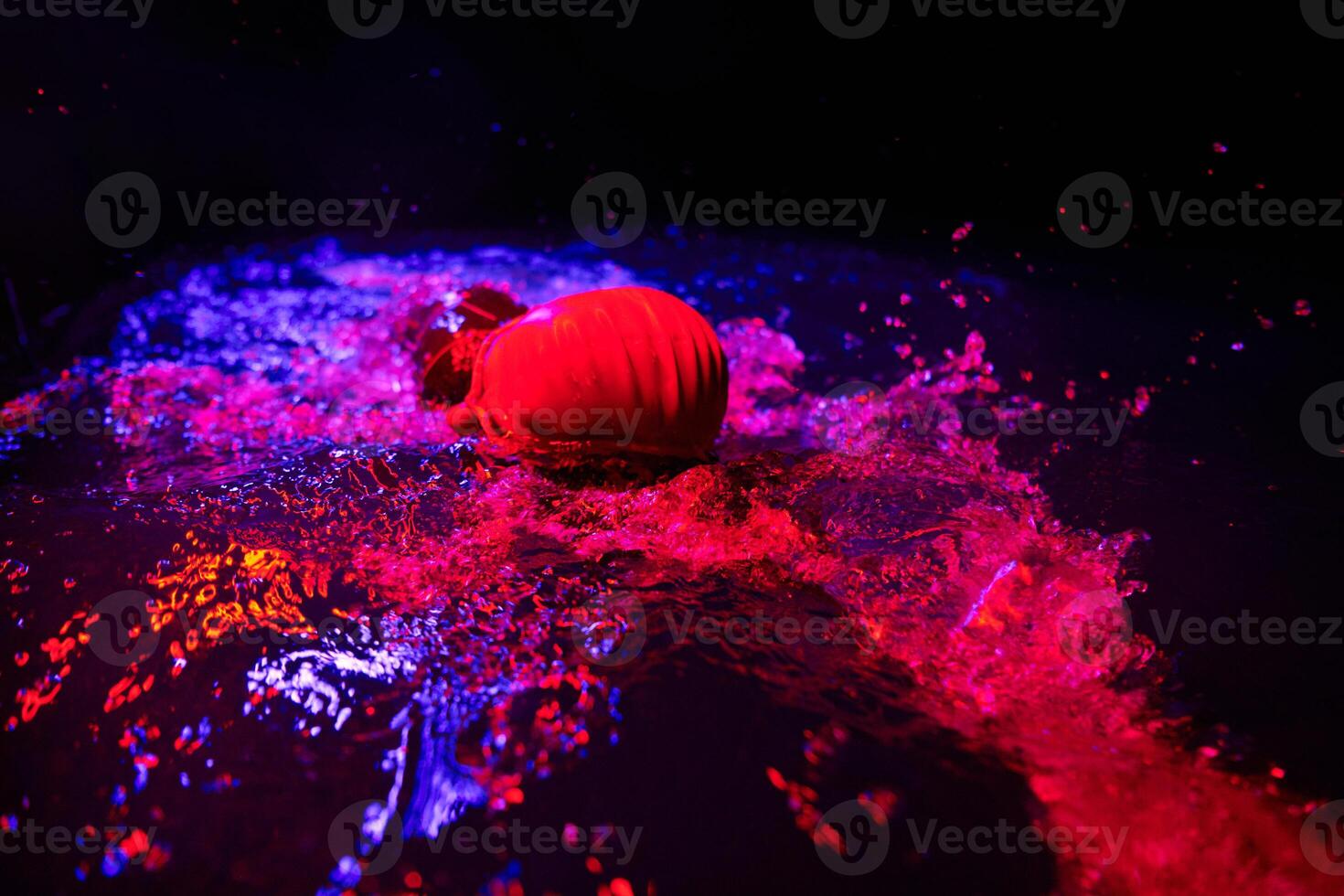 Authentic triathlete swimmer having a break during hard training on night neon gel light photo