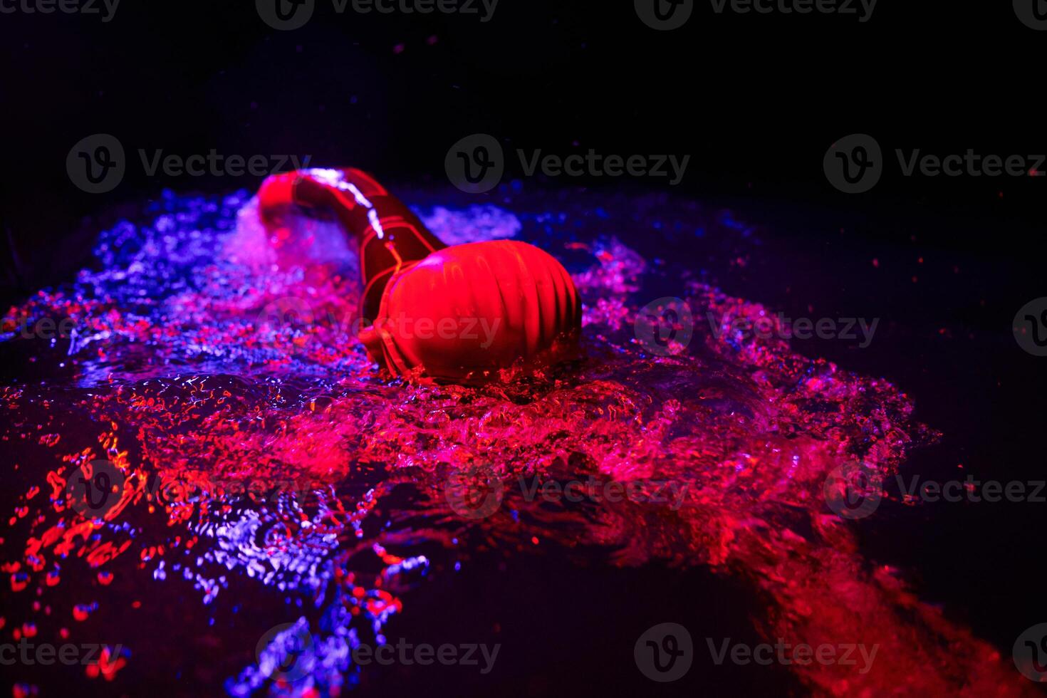 Authentic triathlete swimmer having a break during hard training on night neon gel light photo