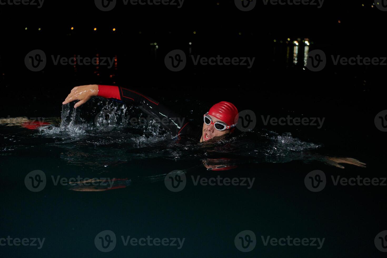 A determined professional triathlete undergoes rigorous night time training in cold waters, showcasing dedication and resilience in preparation for an upcoming triathlon swim competition photo