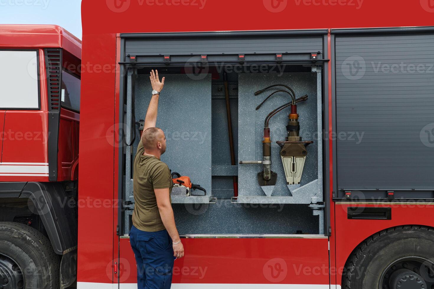 A dedicated firefighter preparing a modern firetruck for deployment to hazardous fire-stricken areas, demonstrating readiness and commitment to emergency response photo