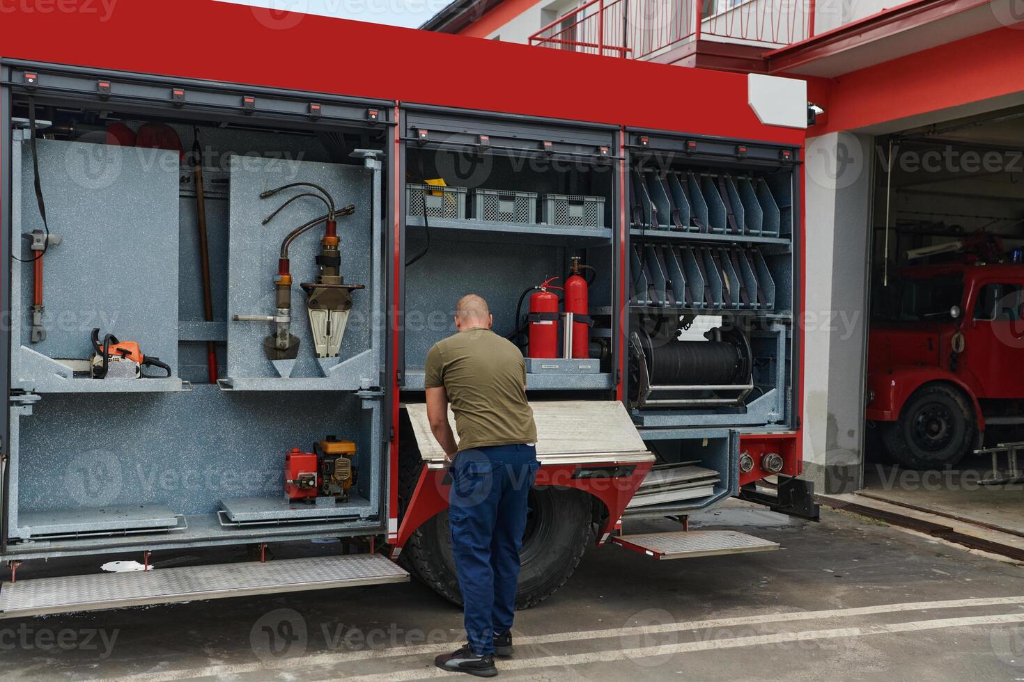 A dedicated firefighter preparing a modern firetruck for deployment to hazardous fire-stricken areas, demonstrating readiness and commitment to emergency response photo