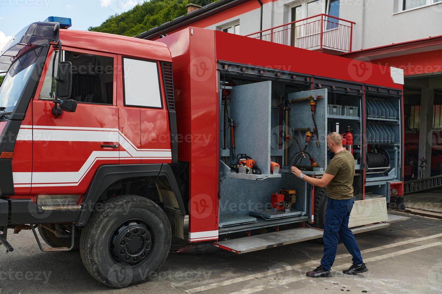 A dedicated firefighter preparing a modern firetruck for deployment to hazardous fire-stricken areas, demonstrating readiness and commitment to emergency response photo