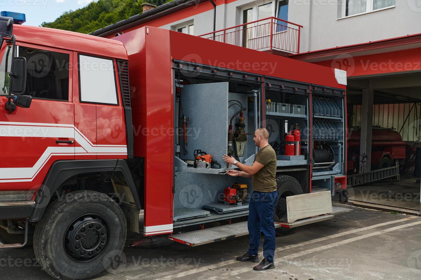 A dedicated firefighter preparing a modern firetruck for deployment to hazardous fire-stricken areas, demonstrating readiness and commitment to emergency response photo