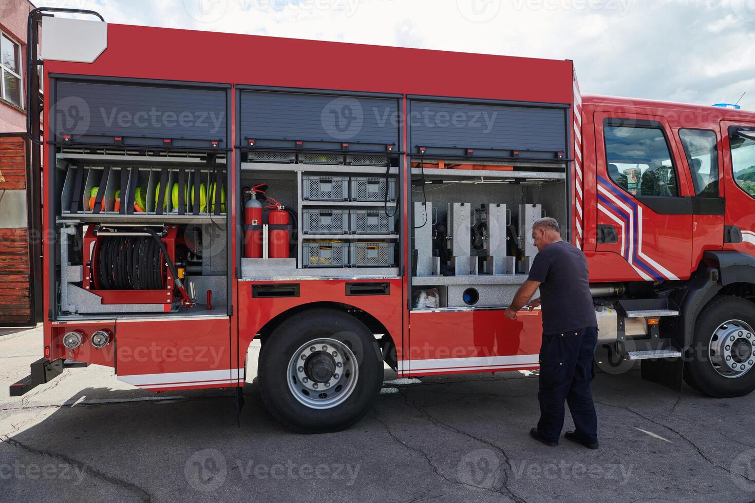 A dedicated firefighter preparing a modern firetruck for deployment to hazardous fire-stricken areas, demonstrating readiness and commitment to emergency response photo