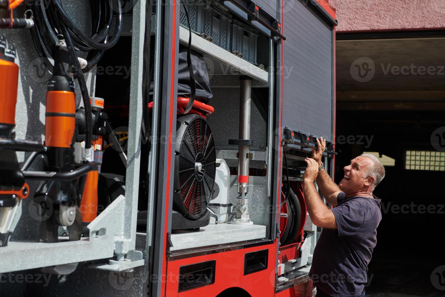 A dedicated firefighter preparing a modern firetruck for deployment to hazardous fire-stricken areas, demonstrating readiness and commitment to emergency response photo