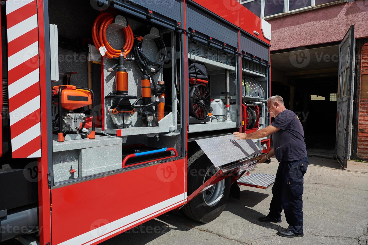 A dedicated firefighter preparing a modern firetruck for deployment to hazardous fire-stricken areas, demonstrating readiness and commitment to emergency response photo