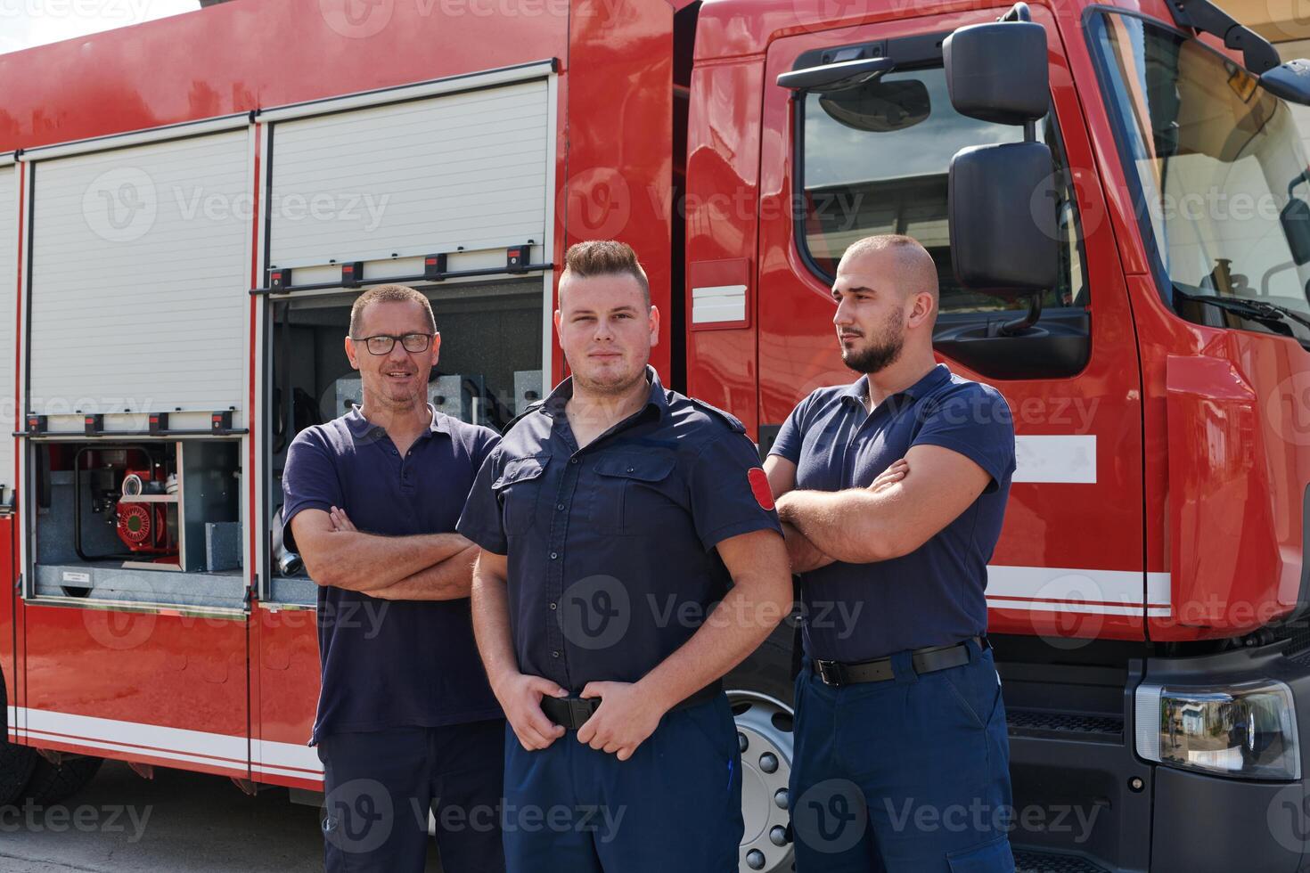 A skilled and dedicated professional firefighting team proudly poses in front of their state of the art firetruck, showcasing their modern equipment and commitment to ensuring public safety. photo