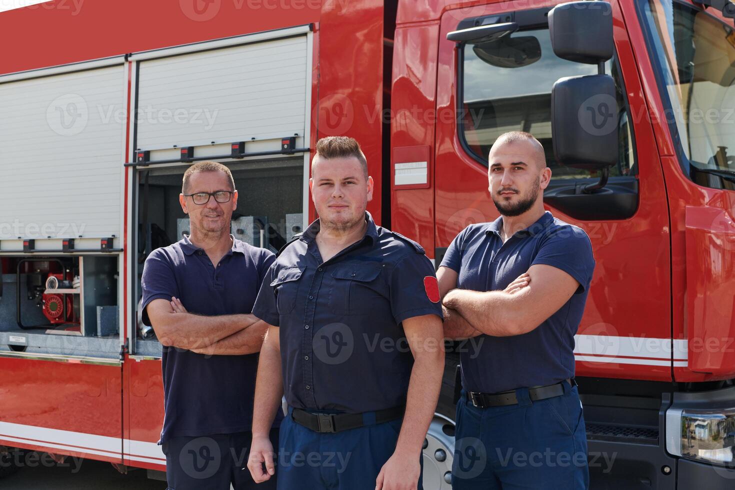 A skilled and dedicated professional firefighting team proudly poses in front of their state of the art firetruck, showcasing their modern equipment and commitment to ensuring public safety. photo