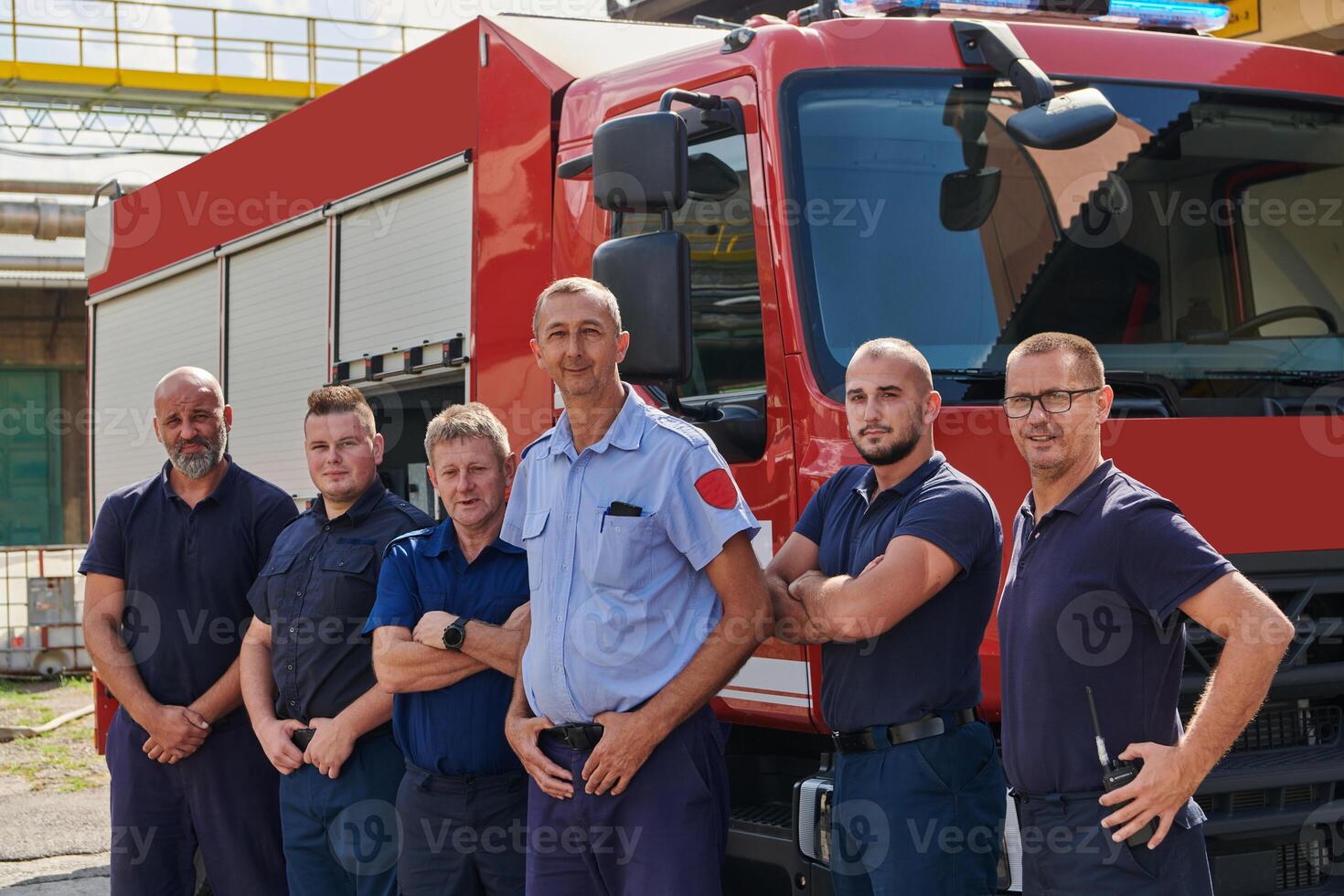 A skilled and dedicated professional firefighting team proudly poses in front of their state of the art firetruck, showcasing their modern equipment and commitment to ensuring public safety. photo