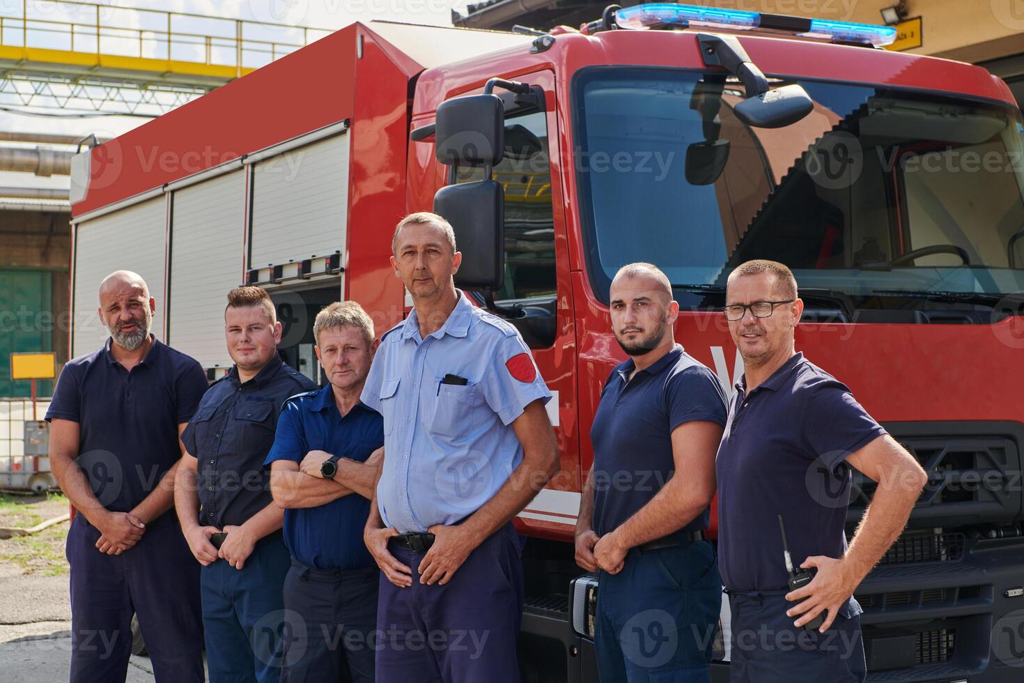 A skilled and dedicated professional firefighting team proudly poses in front of their state of the art firetruck, showcasing their modern equipment and commitment to ensuring public safety. photo