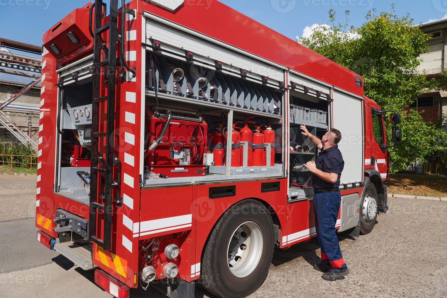 A dedicated firefighter preparing a modern firetruck for deployment to hazardous fire-stricken areas, demonstrating readiness and commitment to emergency response photo