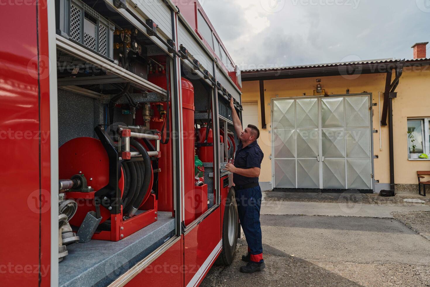 A dedicated firefighter preparing a modern firetruck for deployment to hazardous fire-stricken areas, demonstrating readiness and commitment to emergency response photo