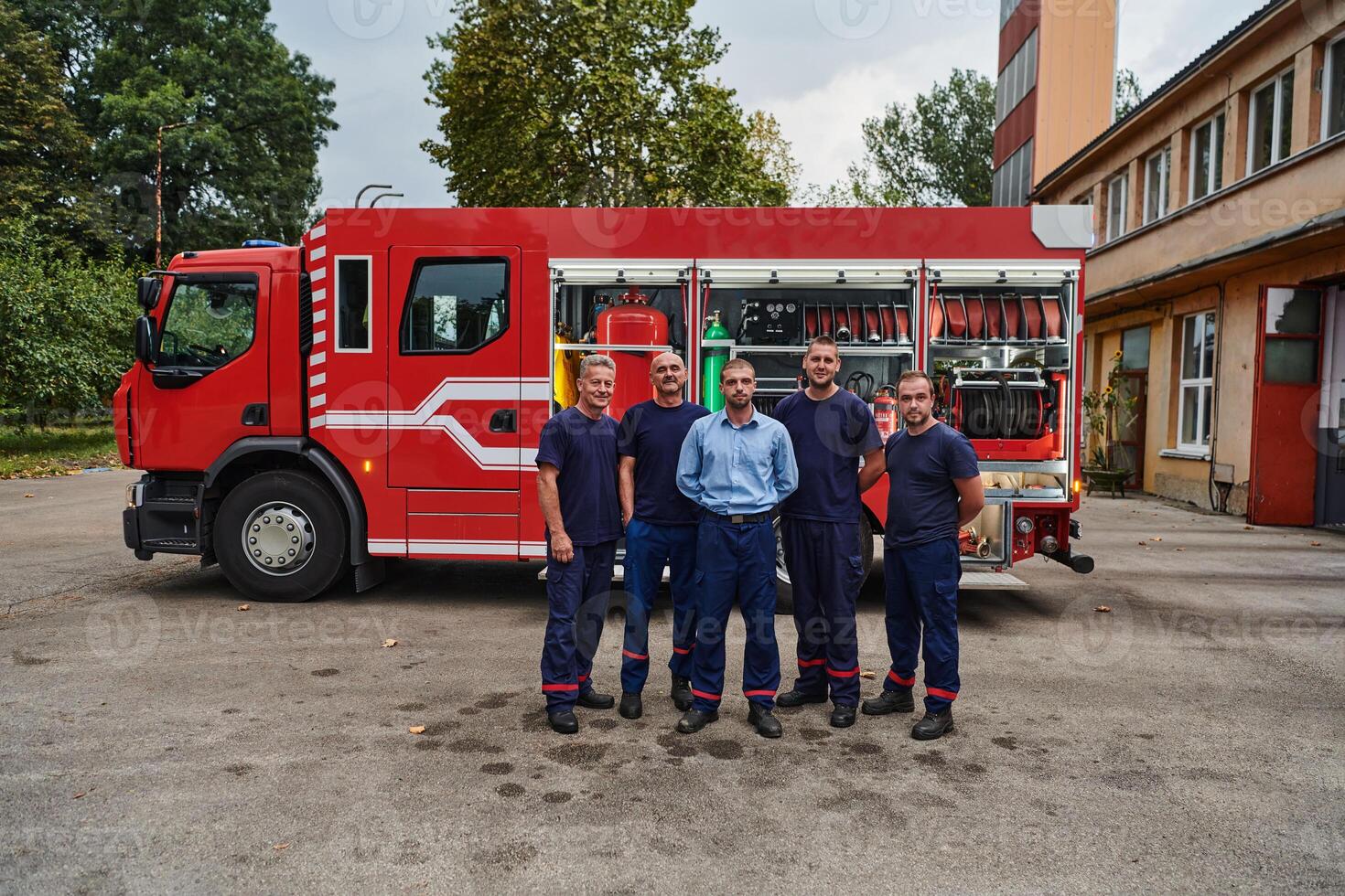A skilled and dedicated professional firefighting team proudly poses in front of their state of the art firetruck, showcasing their modern equipment and commitment to ensuring public safety. photo