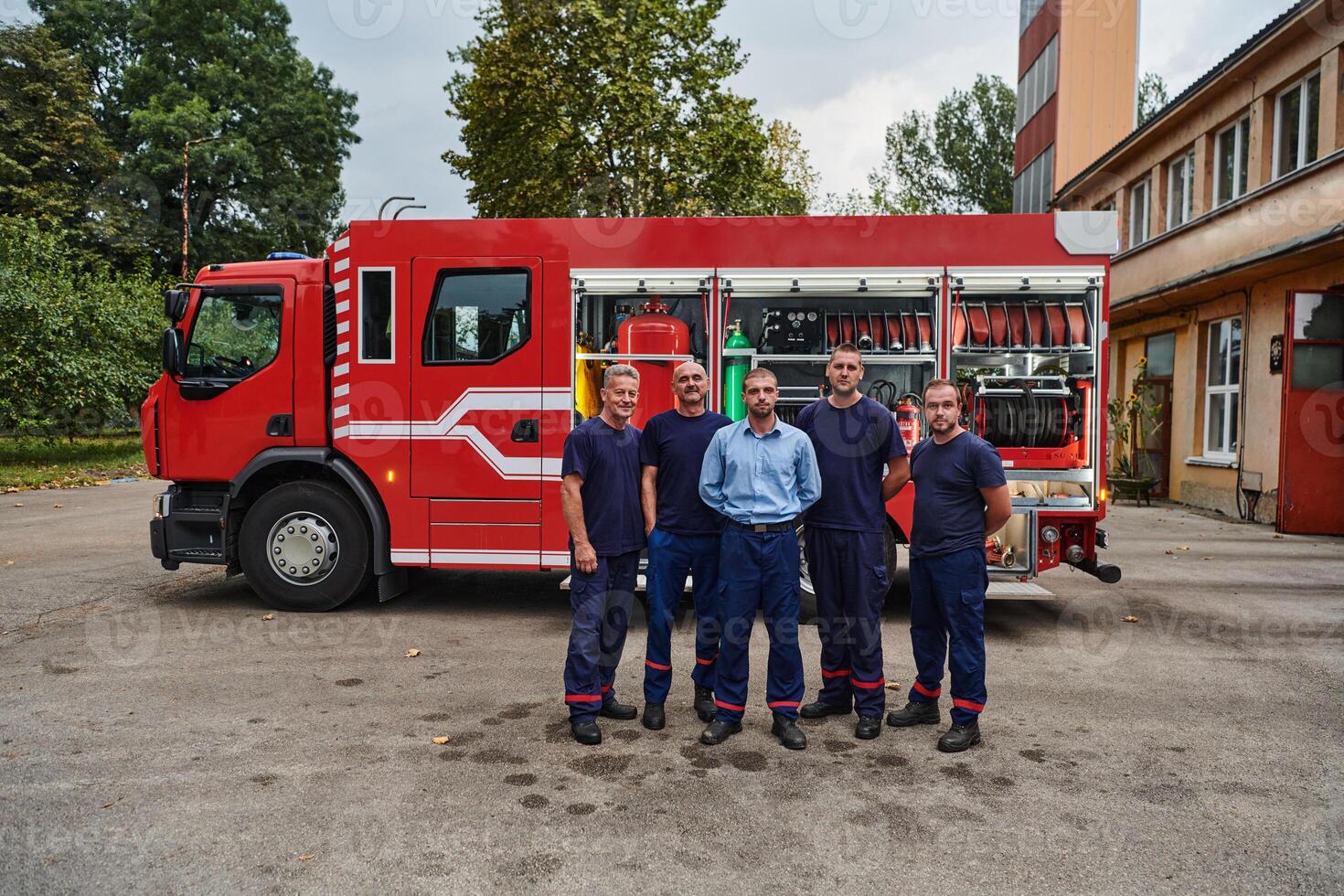 A skilled and dedicated professional firefighting team proudly poses in front of their state of the art firetruck, showcasing their modern equipment and commitment to ensuring public safety. photo
