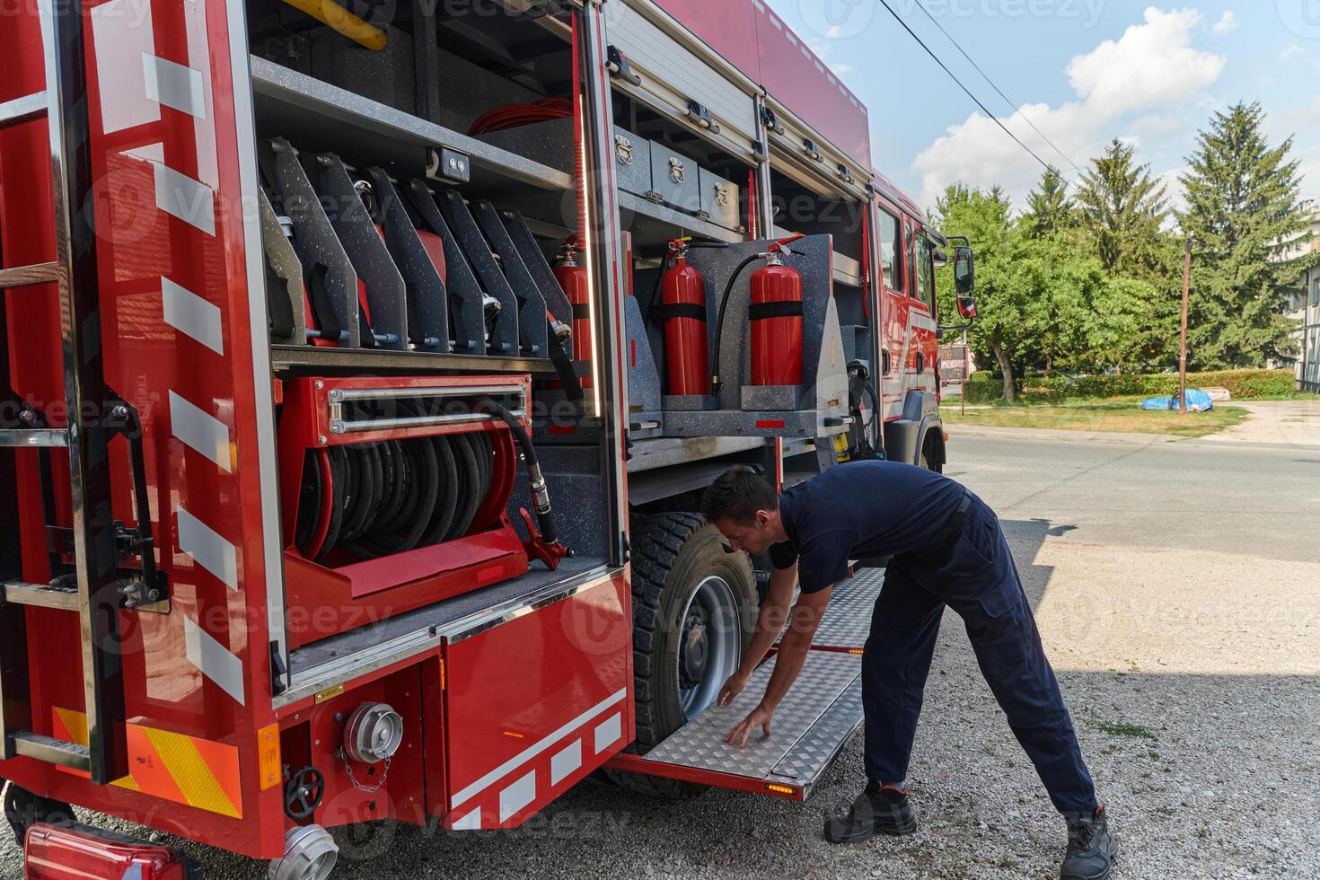 A dedicated firefighter preparing a modern firetruck for deployment to hazardous fire-stricken areas, demonstrating readiness and commitment to emergency response photo
