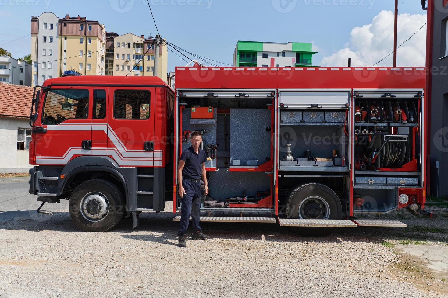 A dedicated firefighter preparing a modern firetruck for deployment to hazardous fire-stricken areas, demonstrating readiness and commitment to emergency response photo