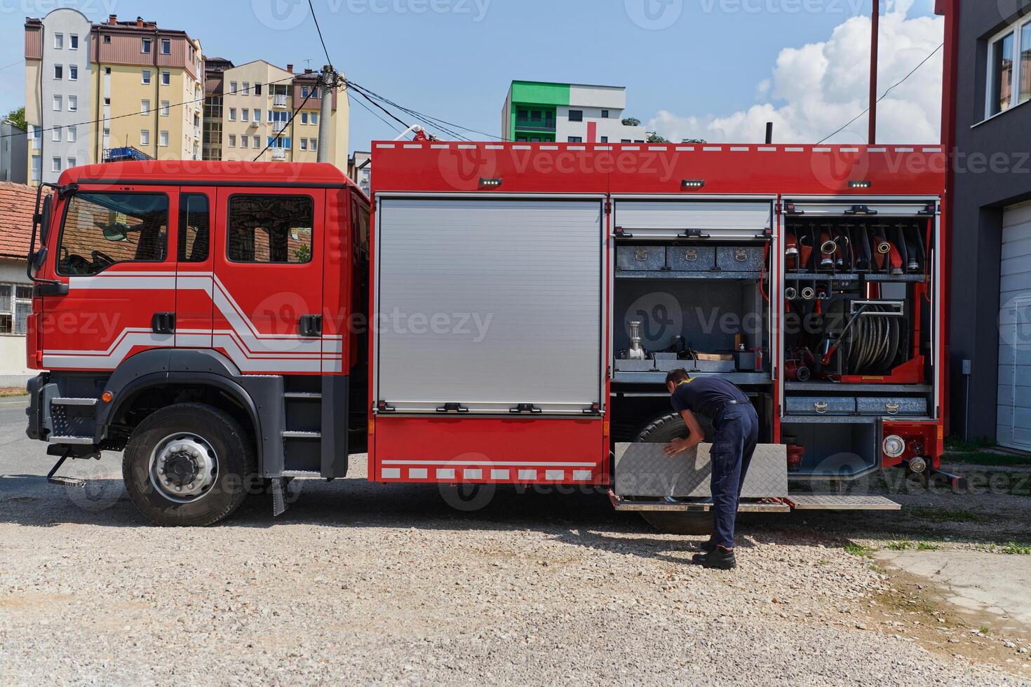 A dedicated firefighter preparing a modern firetruck for deployment to hazardous fire-stricken areas, demonstrating readiness and commitment to emergency response photo