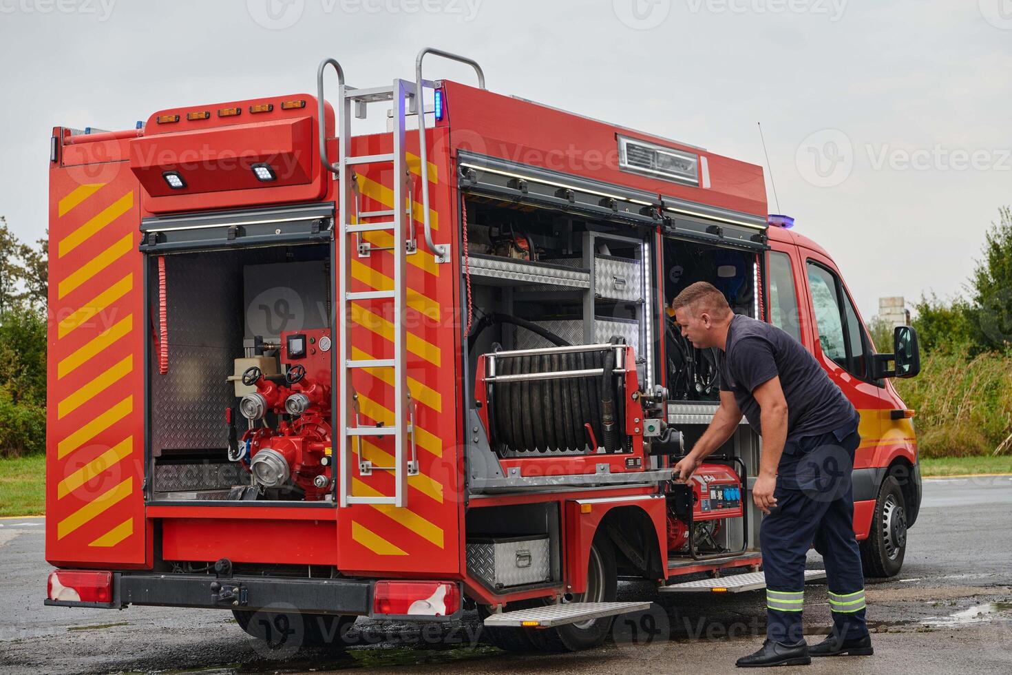 A dedicated firefighter preparing a modern firetruck for deployment to hazardous fire-stricken areas, demonstrating readiness and commitment to emergency response photo
