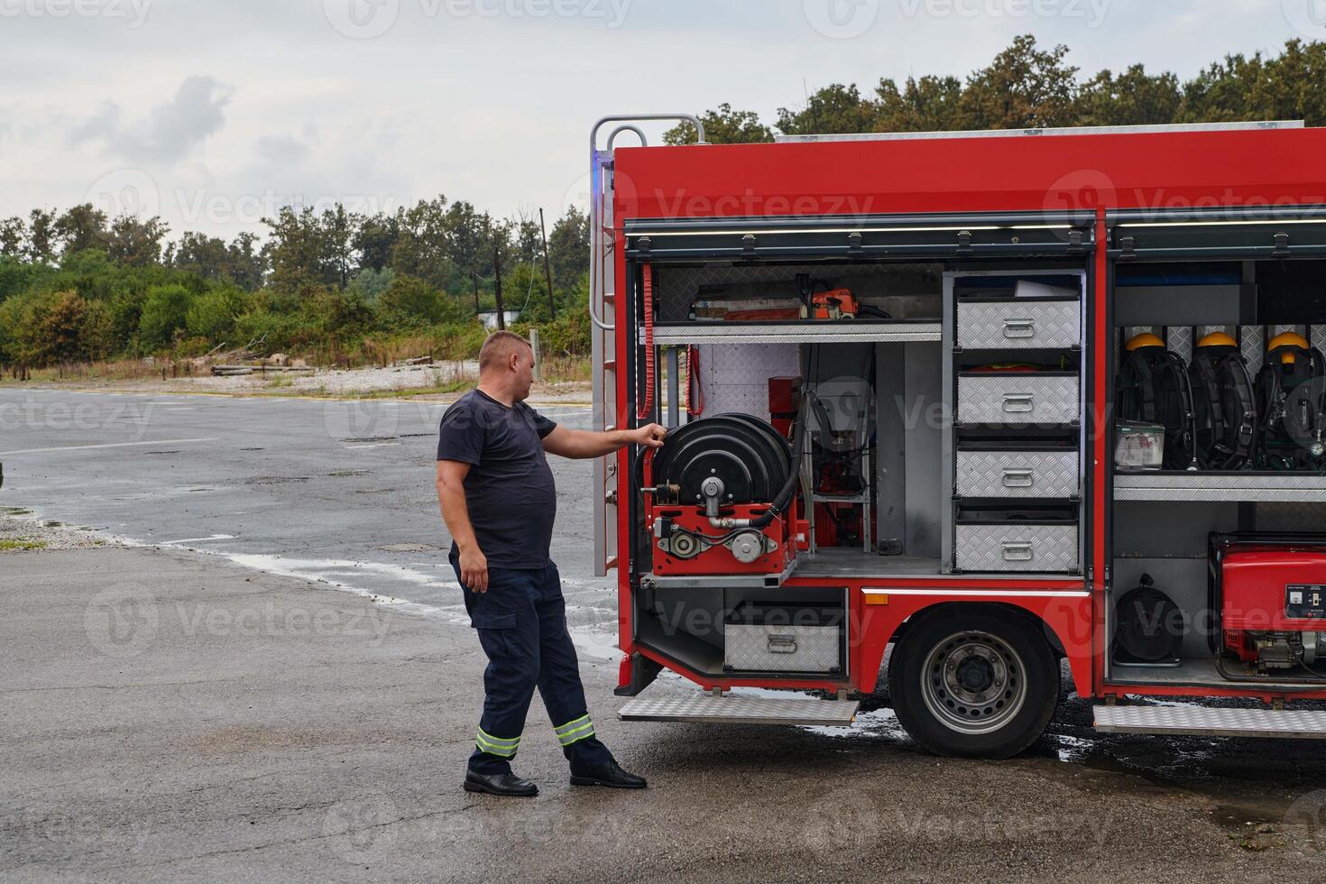A dedicated firefighter preparing a modern firetruck for deployment to hazardous fire-stricken areas, demonstrating readiness and commitment to emergency response photo