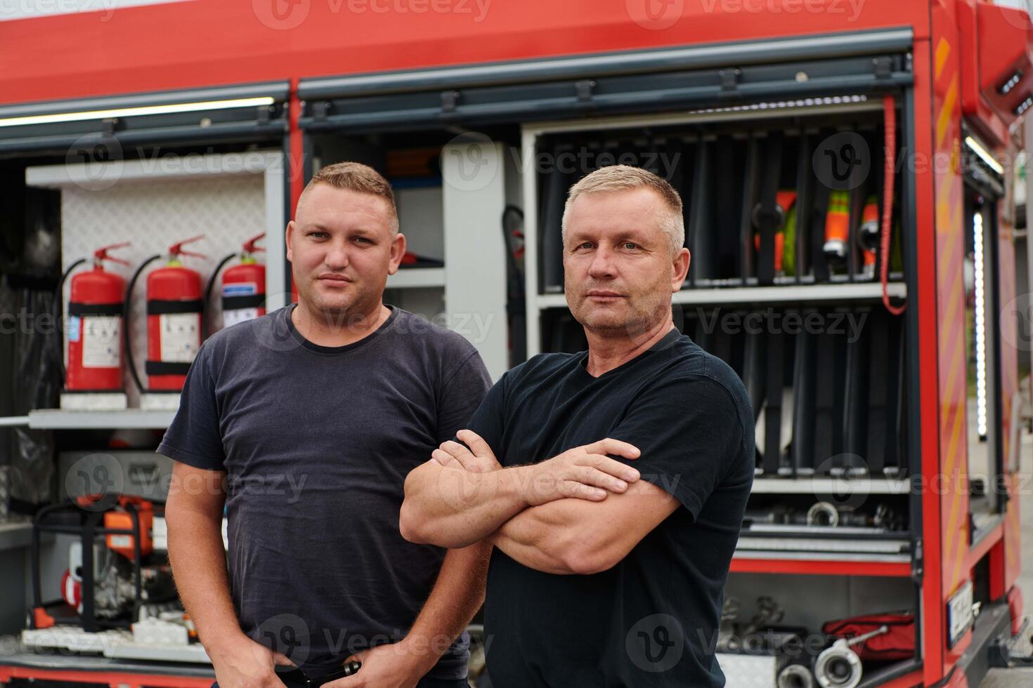 A skilled and dedicated professional firefighting team proudly poses in front of their state of the art firetruck, showcasing their modern equipment and commitment to ensuring public safety. photo