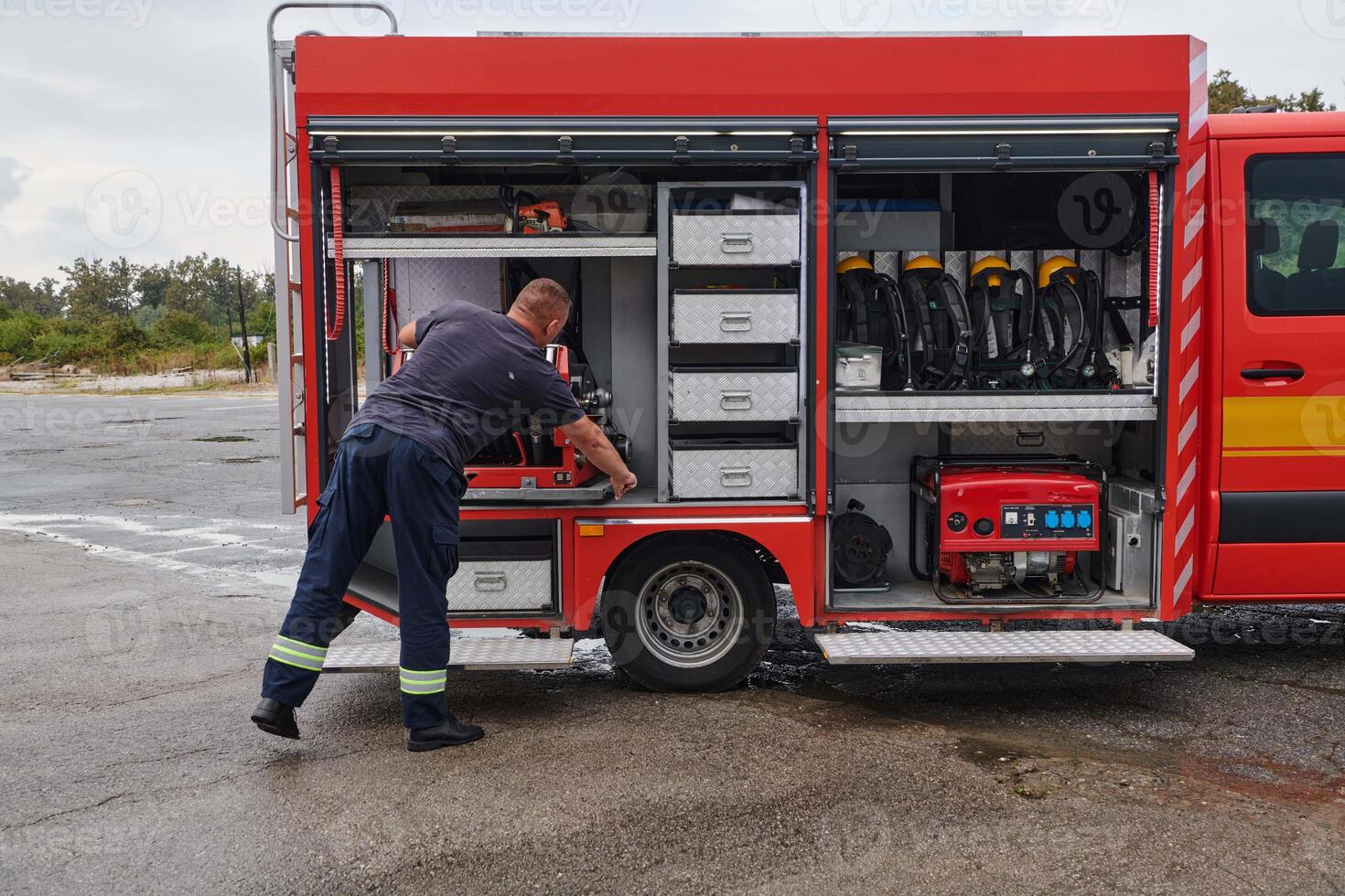 A dedicated firefighter preparing a modern firetruck for deployment to hazardous fire-stricken areas, demonstrating readiness and commitment to emergency response photo