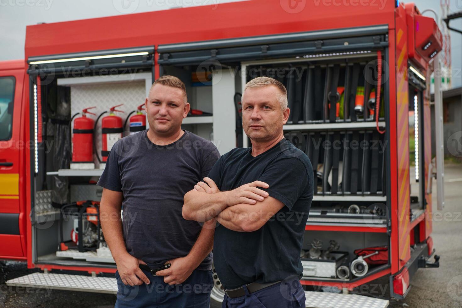 A skilled and dedicated professional firefighting team proudly poses in front of their state of the art firetruck, showcasing their modern equipment and commitment to ensuring public safety. photo
