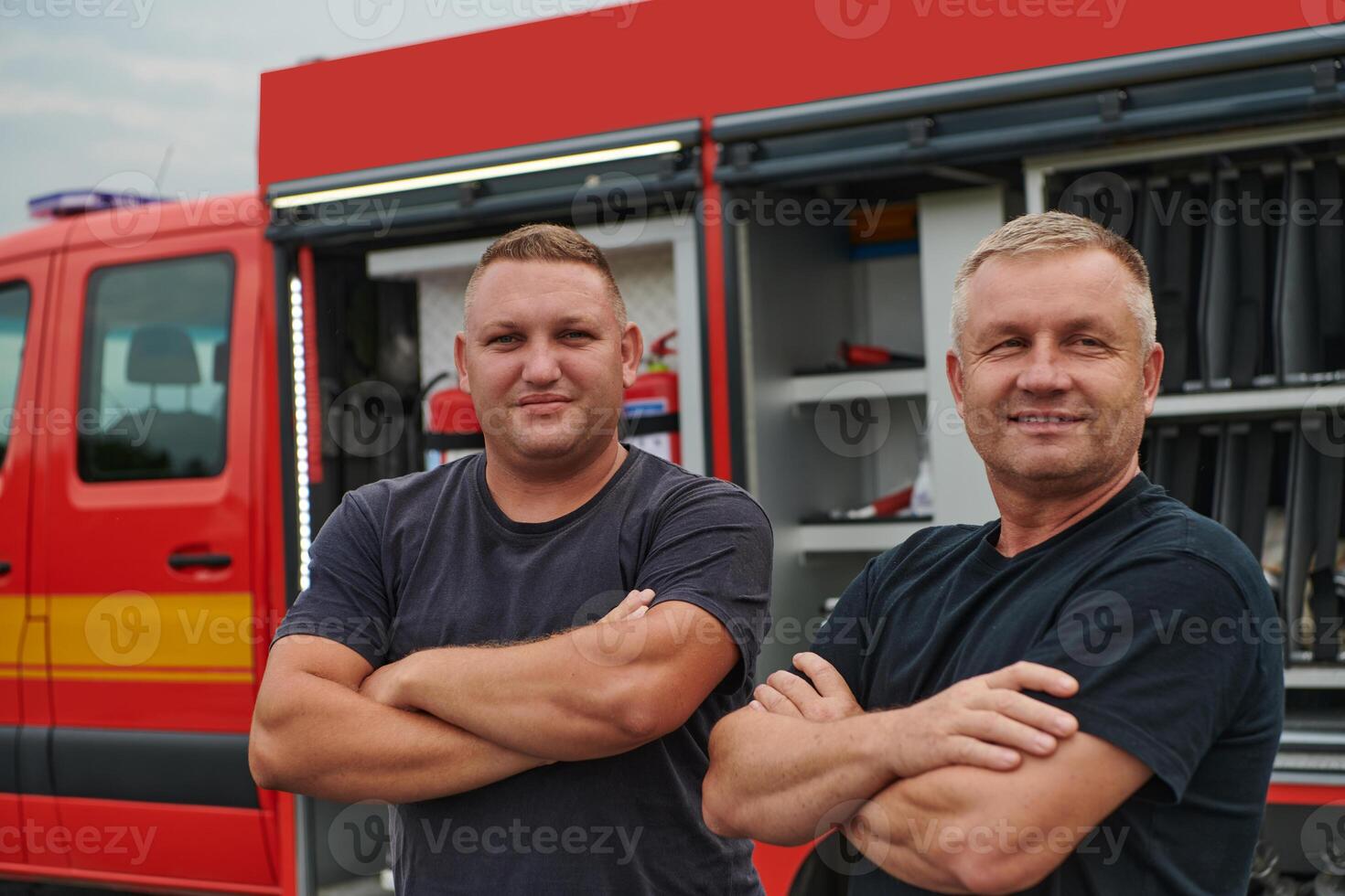 A skilled and dedicated professional firefighting team proudly poses in front of their state of the art firetruck, showcasing their modern equipment and commitment to ensuring public safety. photo