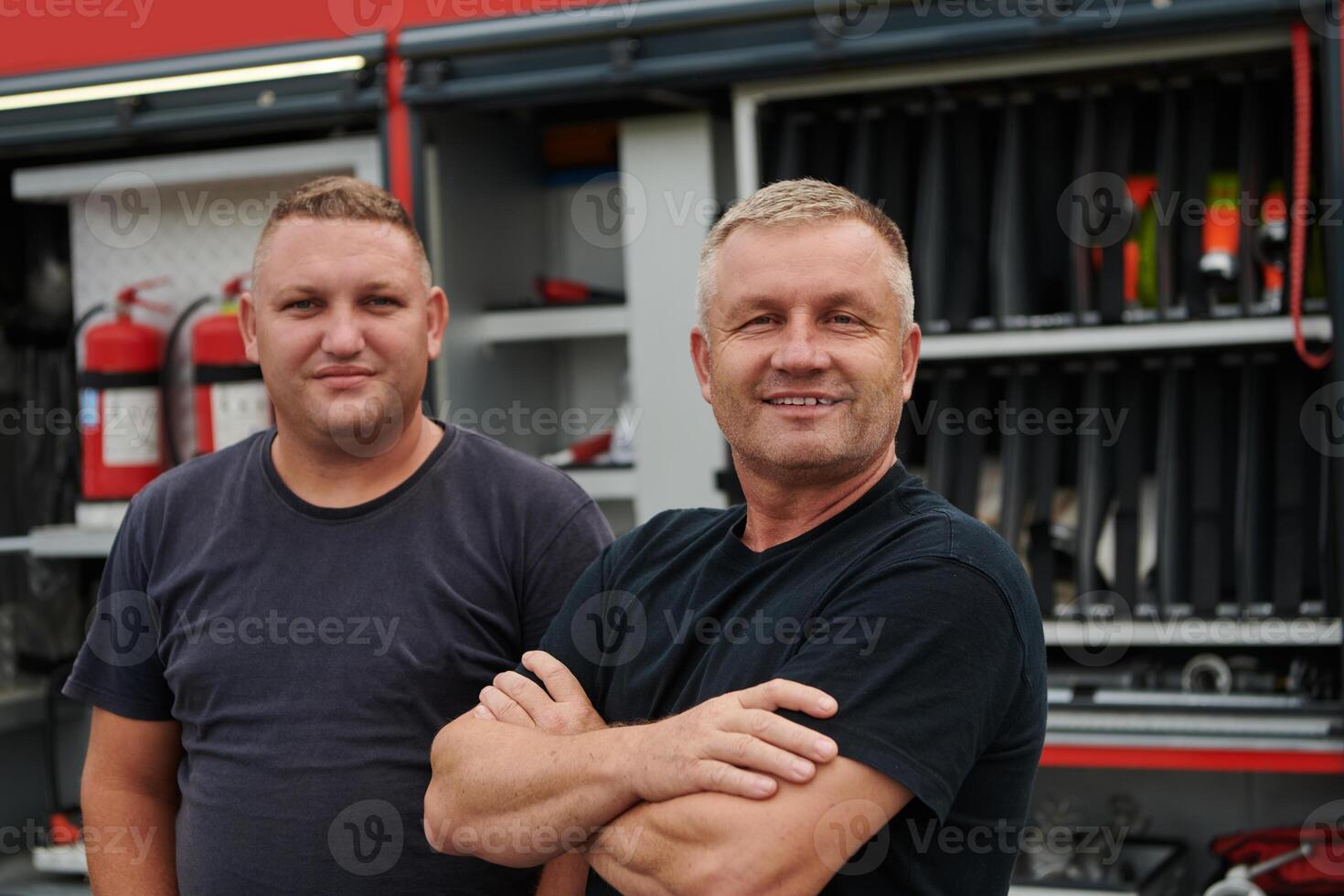 A skilled and dedicated professional firefighting team proudly poses in front of their state of the art firetruck, showcasing their modern equipment and commitment to ensuring public safety. photo