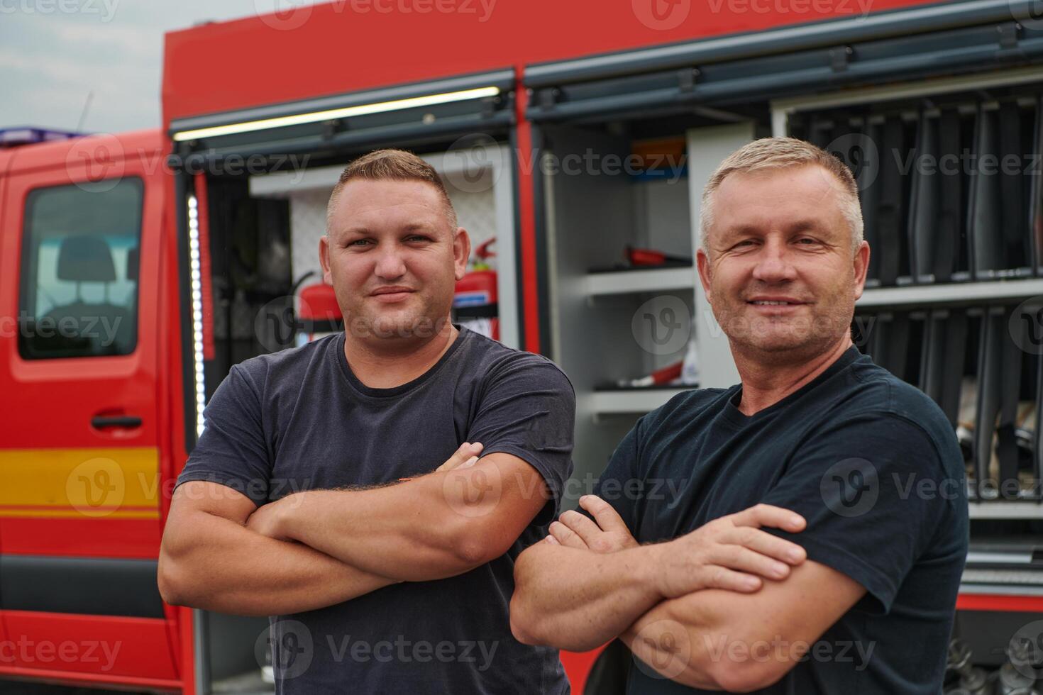 A skilled and dedicated professional firefighting team proudly poses in front of their state of the art firetruck, showcasing their modern equipment and commitment to ensuring public safety. photo