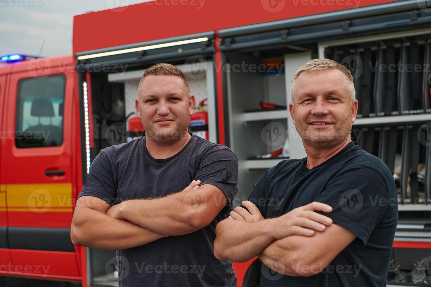 A skilled and dedicated professional firefighting team proudly poses in front of their state of the art firetruck, showcasing their modern equipment and commitment to ensuring public safety. photo