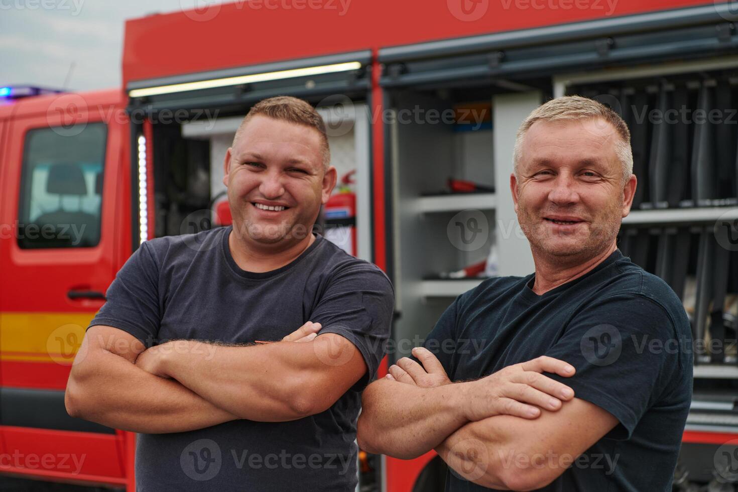 A skilled and dedicated professional firefighting team proudly poses in front of their state of the art firetruck, showcasing their modern equipment and commitment to ensuring public safety. photo