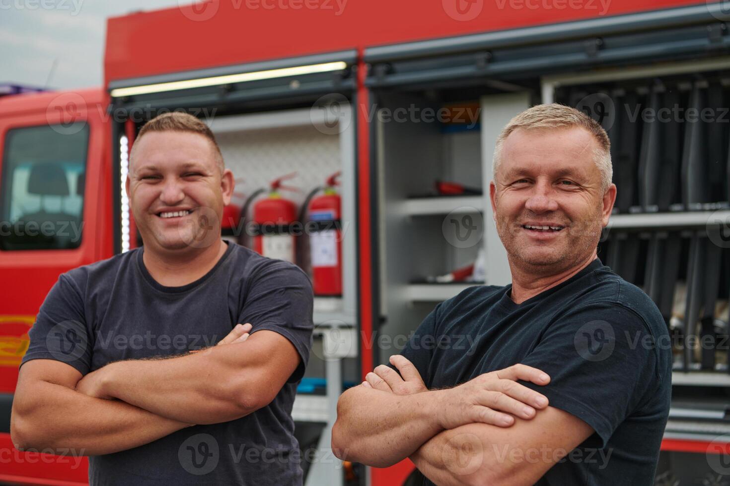 A skilled and dedicated professional firefighting team proudly poses in front of their state of the art firetruck, showcasing their modern equipment and commitment to ensuring public safety. photo