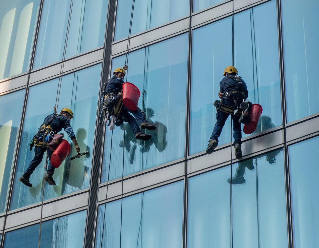 Milan Italy 2023 Skilled glass cleaners who lower themselves with slings from above photo
